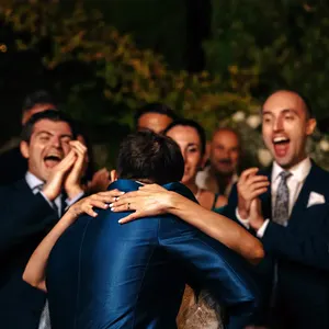 Um abraço entre amigos no meio da festa.